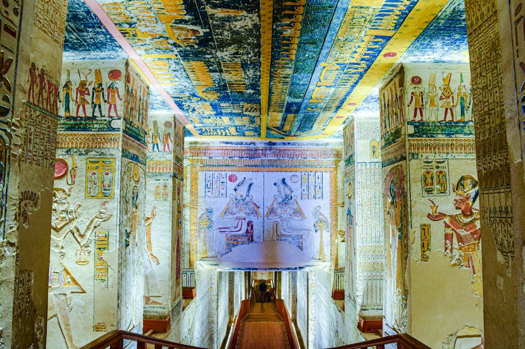 Explore a vividly decorated corridor in an ancient Egyptian tomb, showcasing vibrant hieroglyphs and artwork.