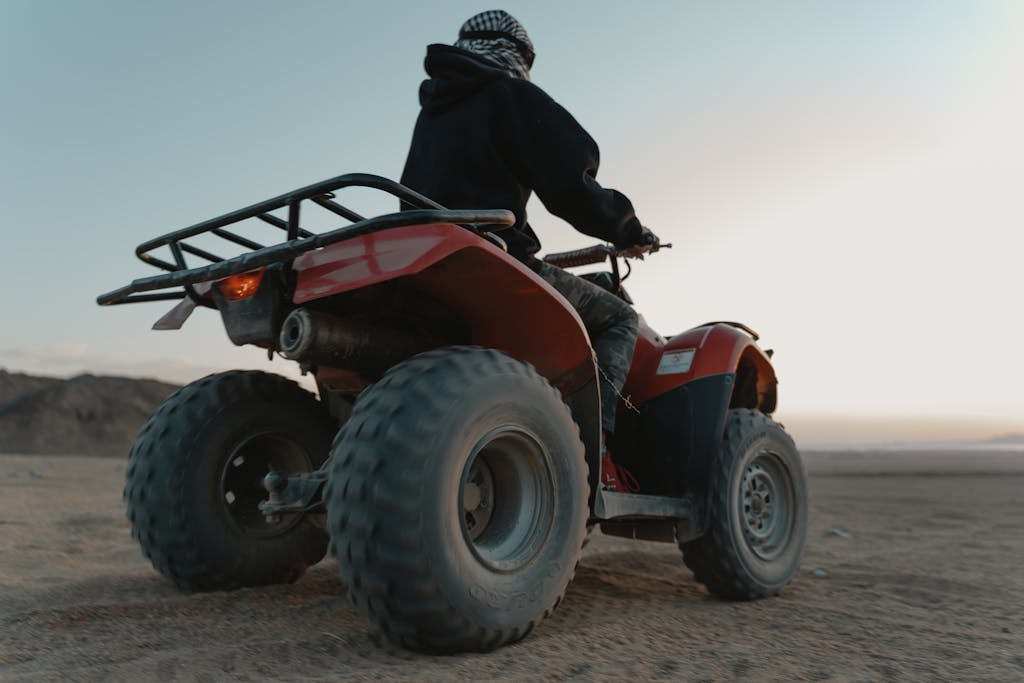 Man riding a quad bike in the desert at dawn, capturing adventure and thrill.