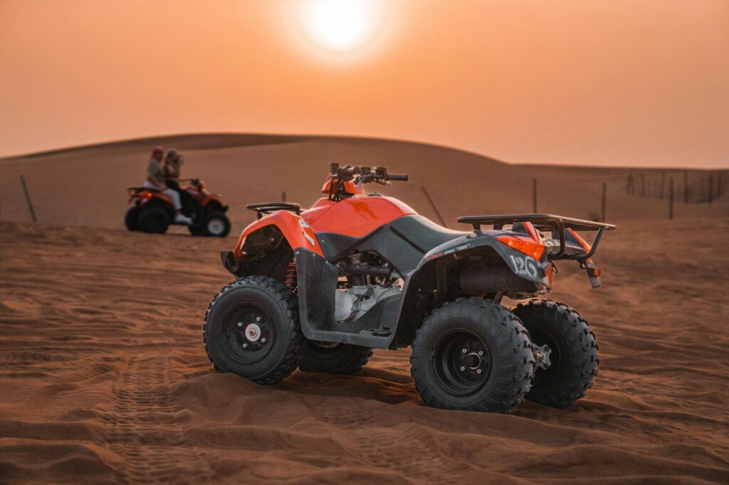 quad on barren desert at sunset