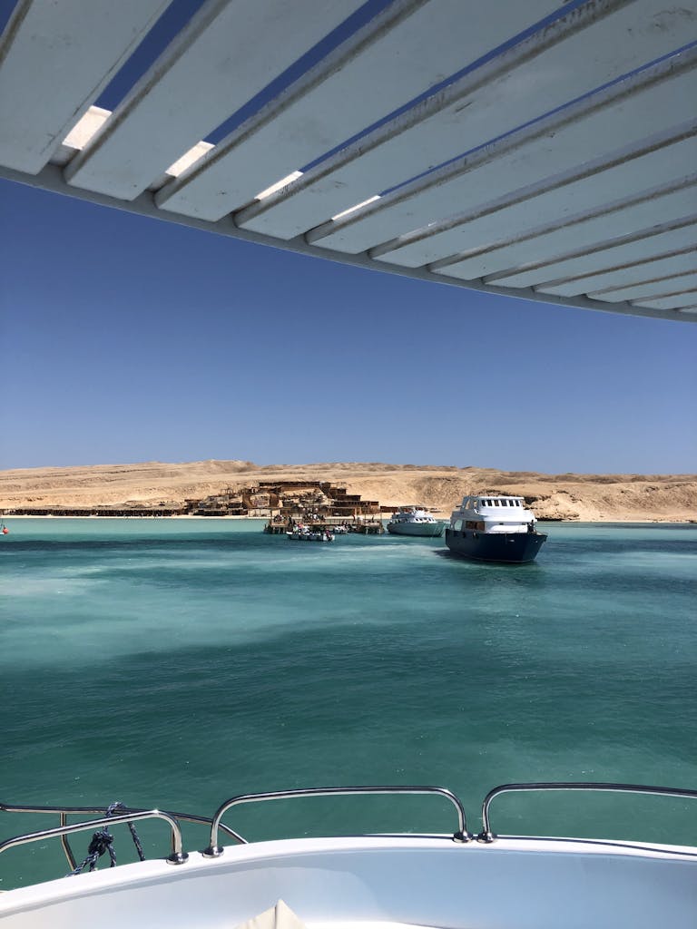 Scenic view of boats near the dock along Egypt's Red Sea coastline under clear blue skies.