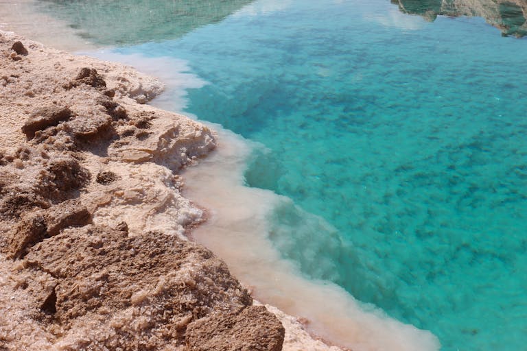 Stunning view of a turquoise salt lake surrounded by rocky desert terrain, a natural marvel.