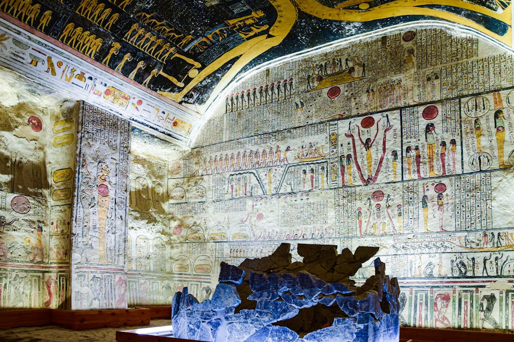 Vibrant frescoes and hieroglyphics inside an ancient Egyptian tomb showcasing historic art and culture.